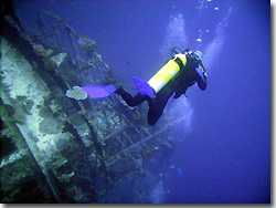 A diver descending on the Taiyo Fishingboat Wreck, Seghi Island. Uepi, Solomon Islands